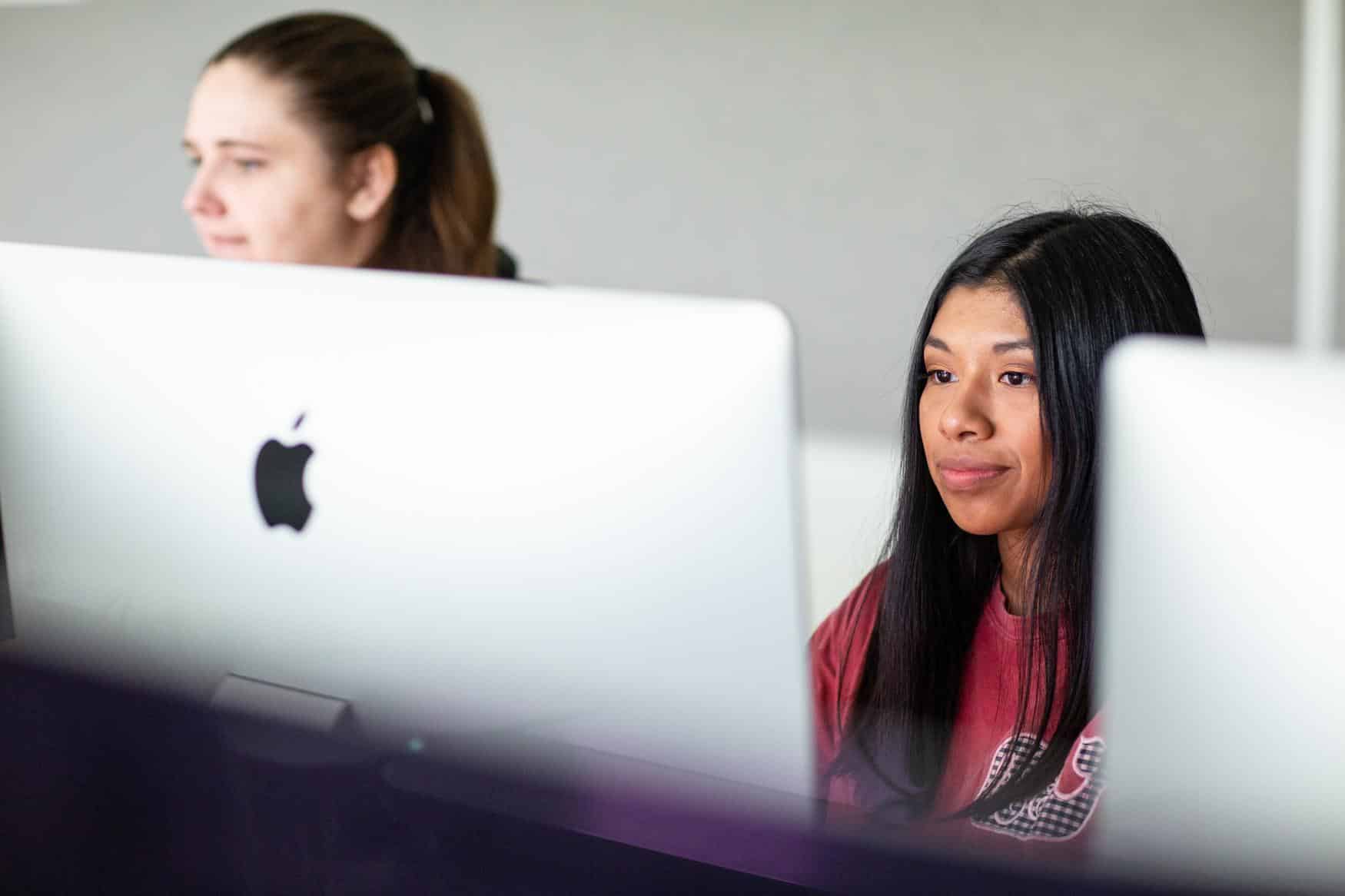 Two female students working on Mac computers
