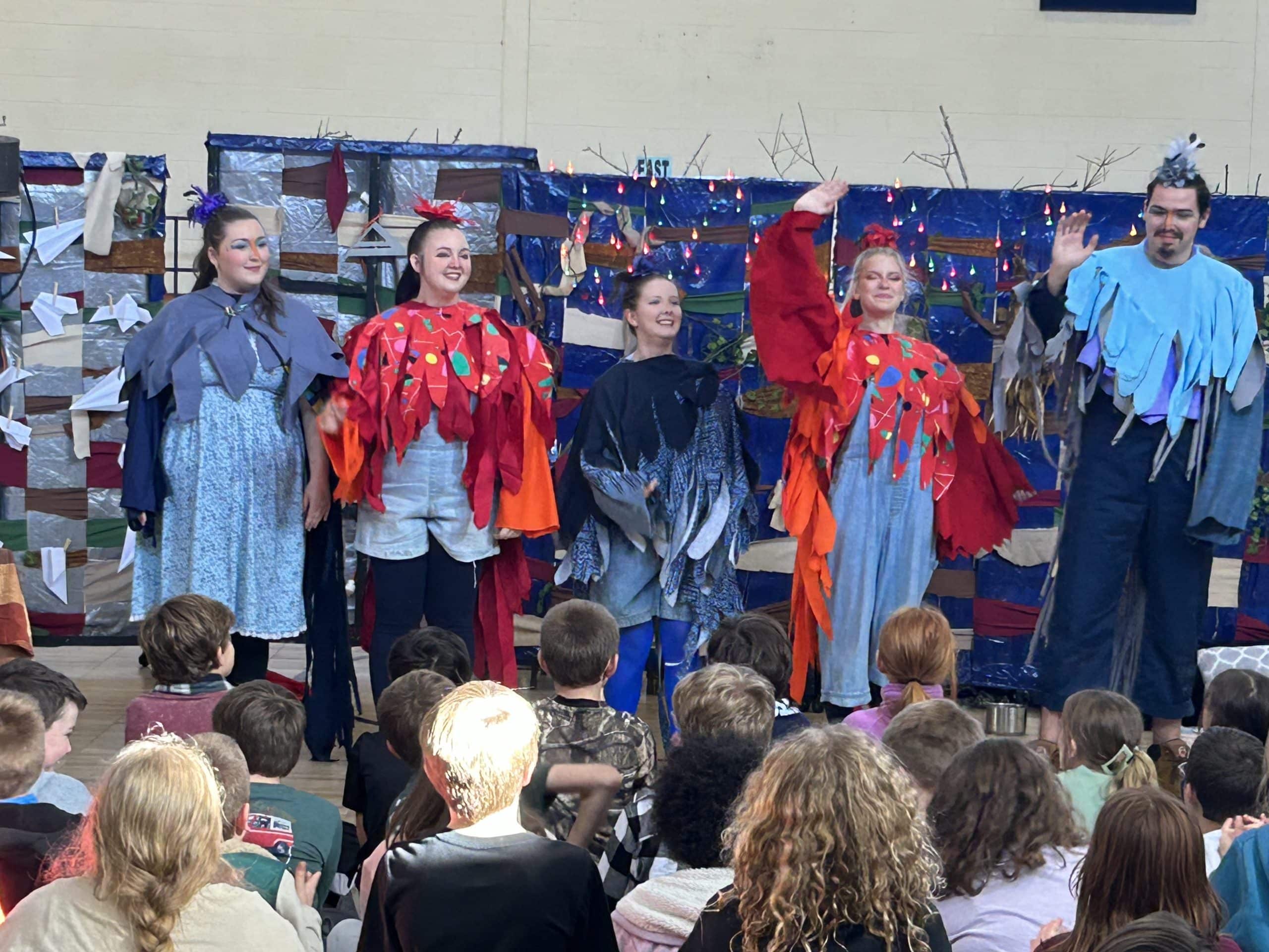 Five Piedmont students performing for a group of children