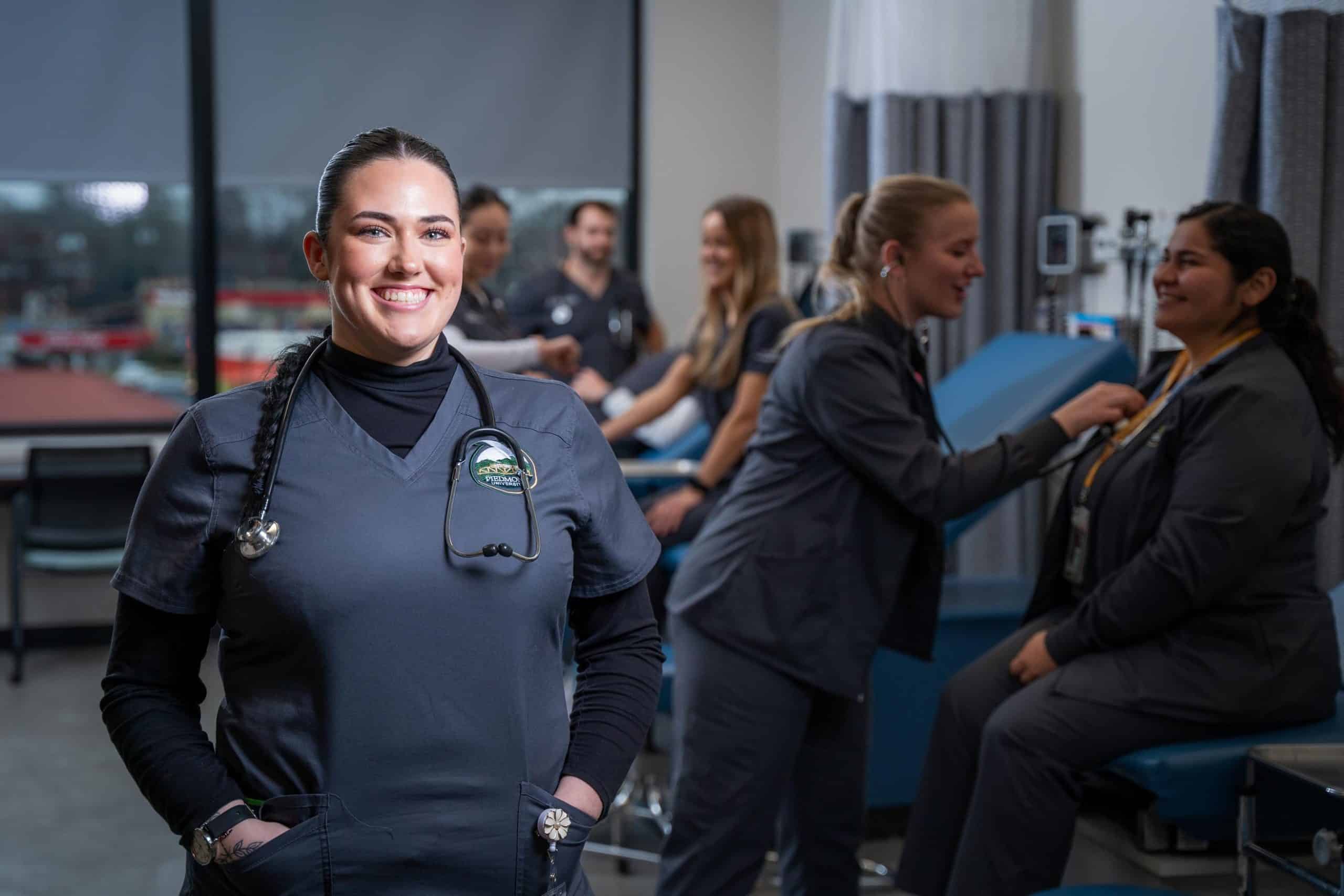 Nursing student smiling and posing for an image. In the background other nursing students are seen.