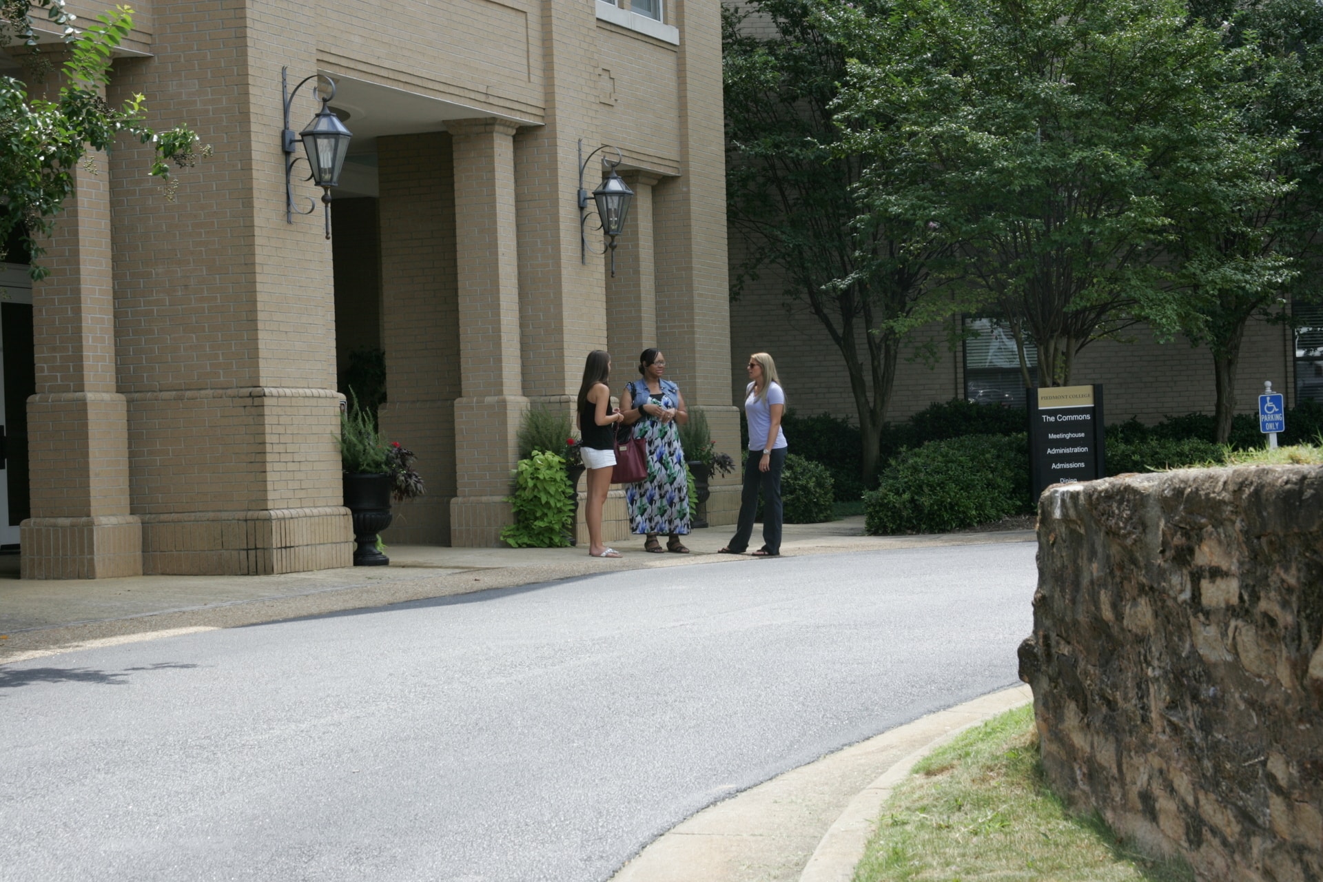 Three students gather at the entrance of the commons