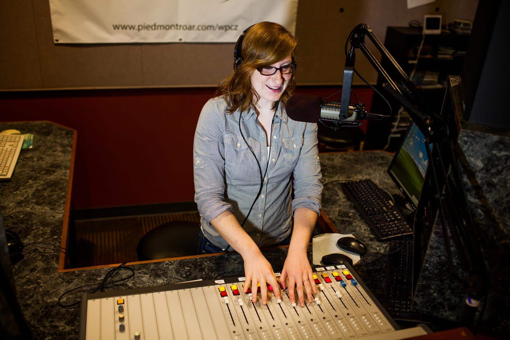 Student at a sound board speaking into a microphone