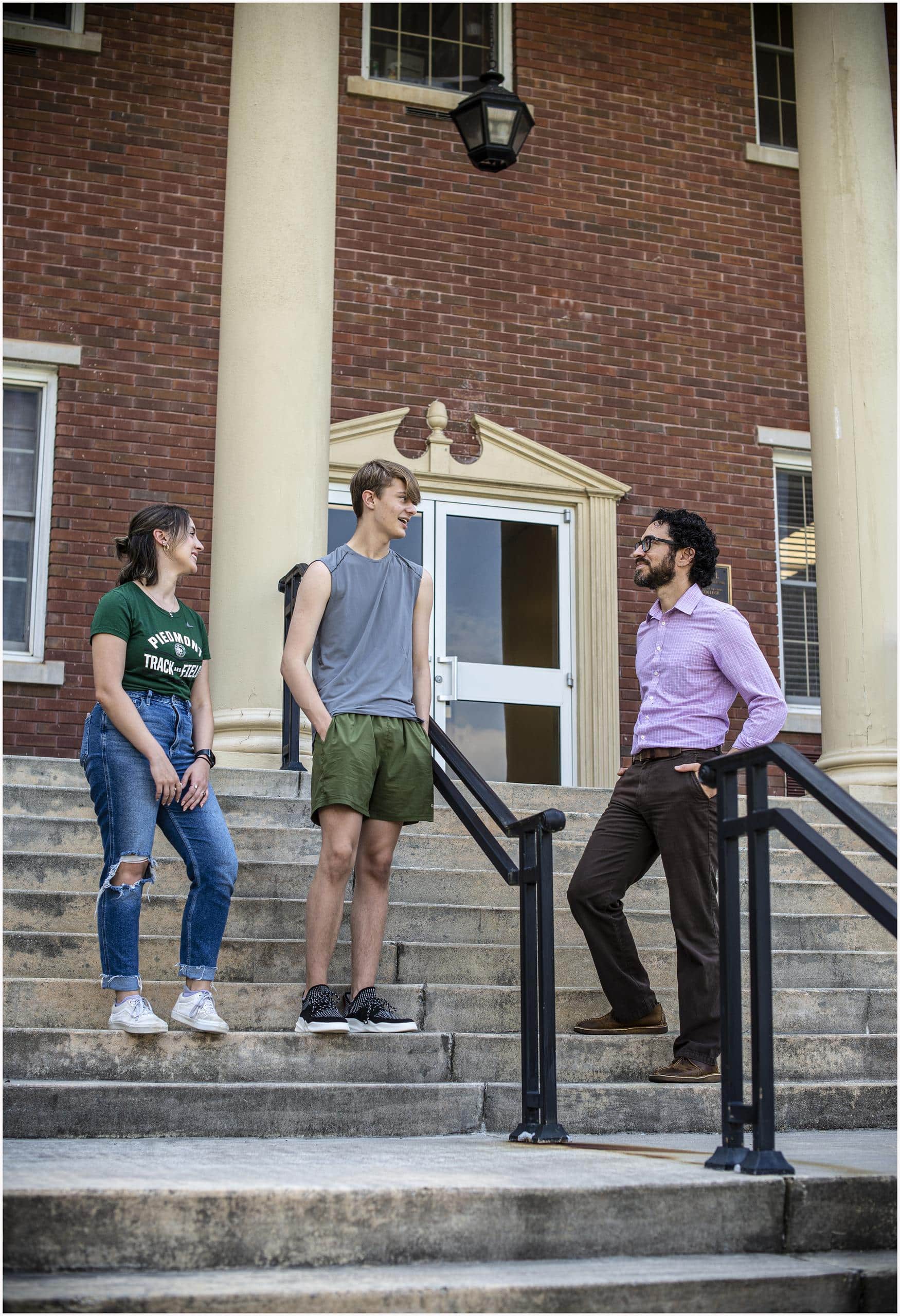 Group of people standing on the stairs in front of a building.