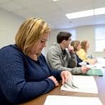 A row of students listening to a lecture