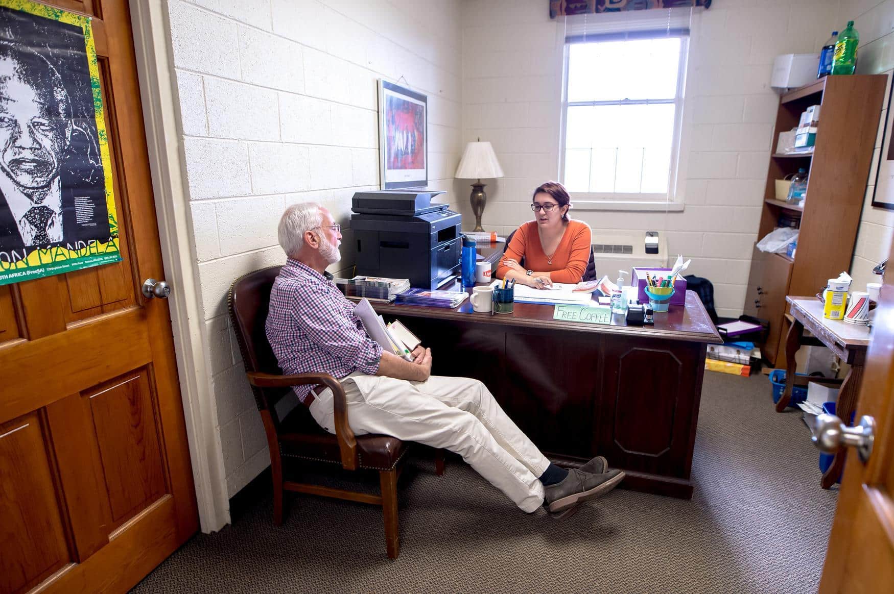Two adults sitting in an office having a conversation