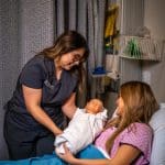 Nursing students practice with a infant medical dummy