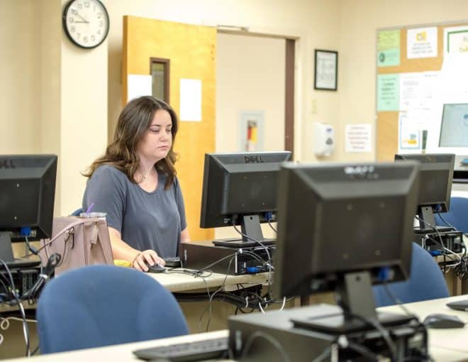 Young woman in a computer lab working on a desktop computer