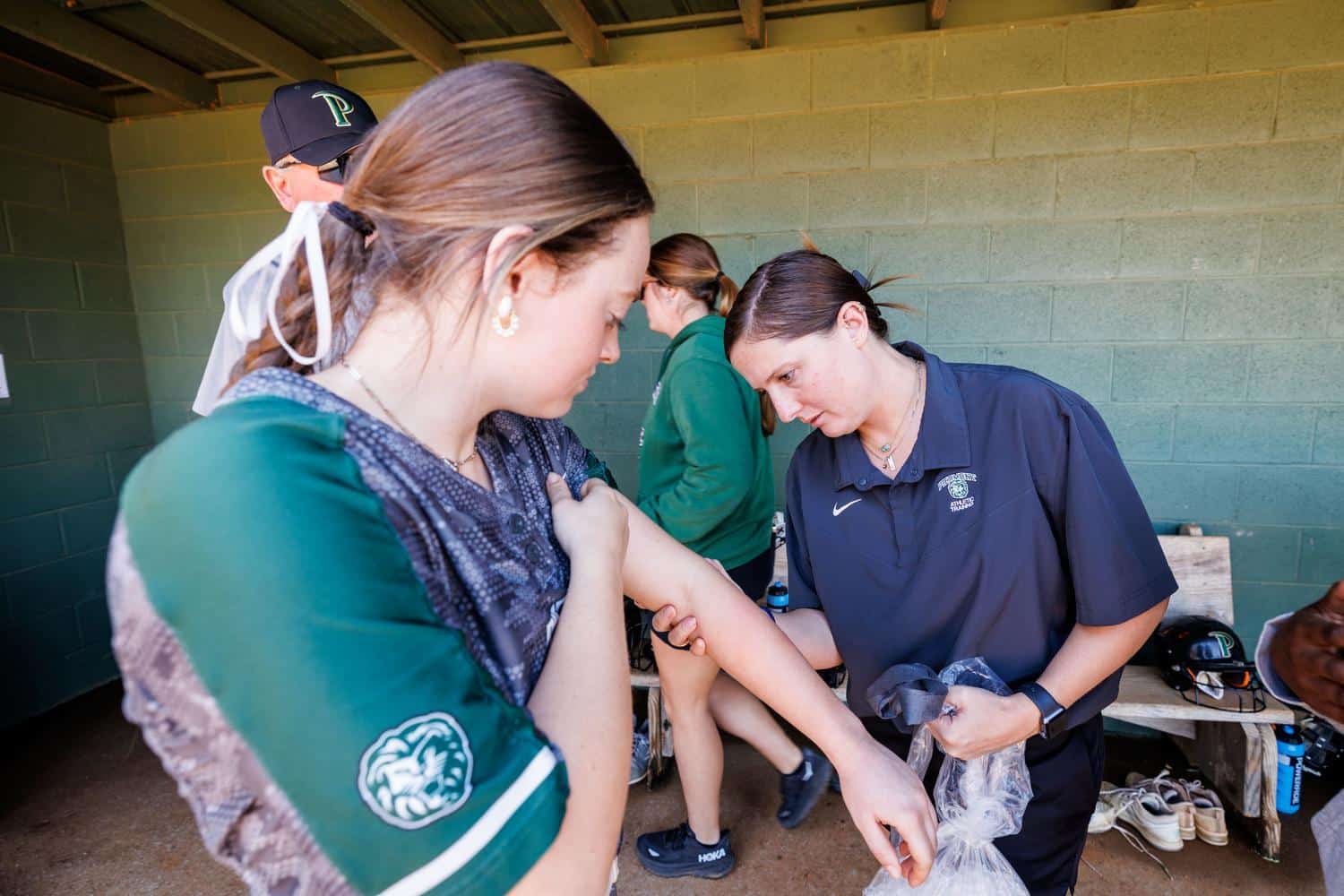 athletic trainer reviewing arm after softball injury
