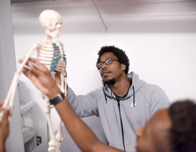 Student looking at skeleton in class