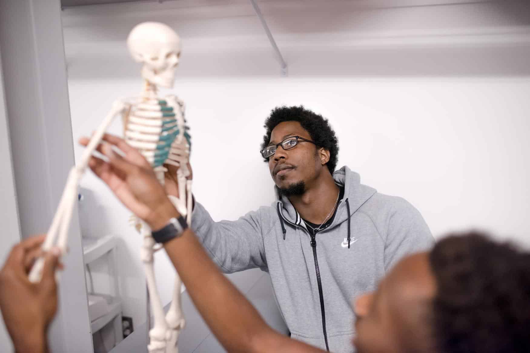 Student looking at skeleton in class