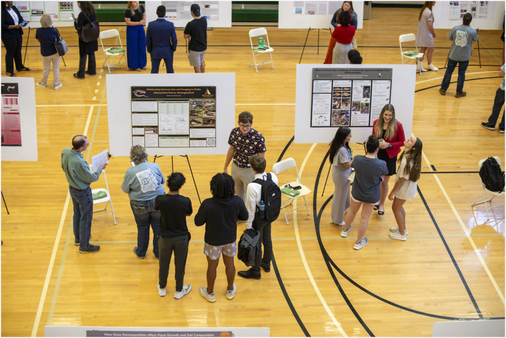 Students in gym with poster presentations