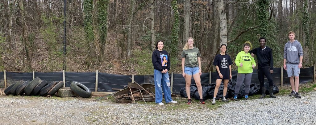 Volunteers with tires, scrap metal and other trash they collected on campus during a cleanup project.