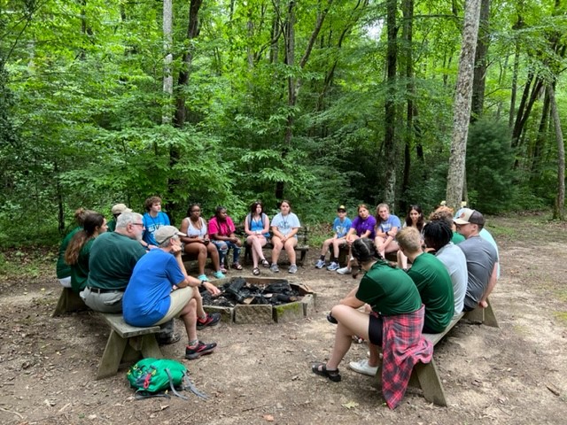 Team huddle around fire pit.