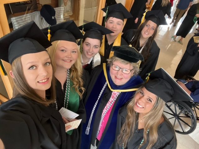 Professor and students at Commencement 2023.