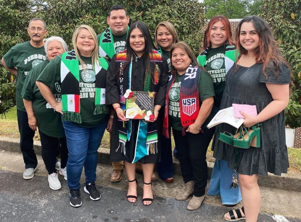 Student surrounded by family members on graduation day.