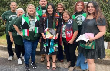 Student surrounded by family members on graduation day.