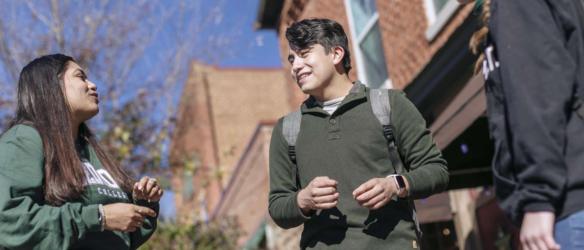 A man wearing a backpack and standing outside a building.