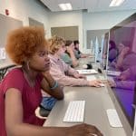 A row of students working on Mac computers