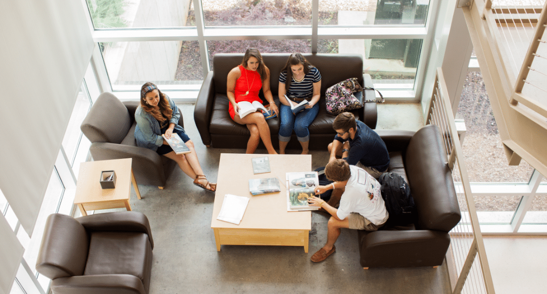 Overhead view of a group of students studying together on a cluster of couches and chairs