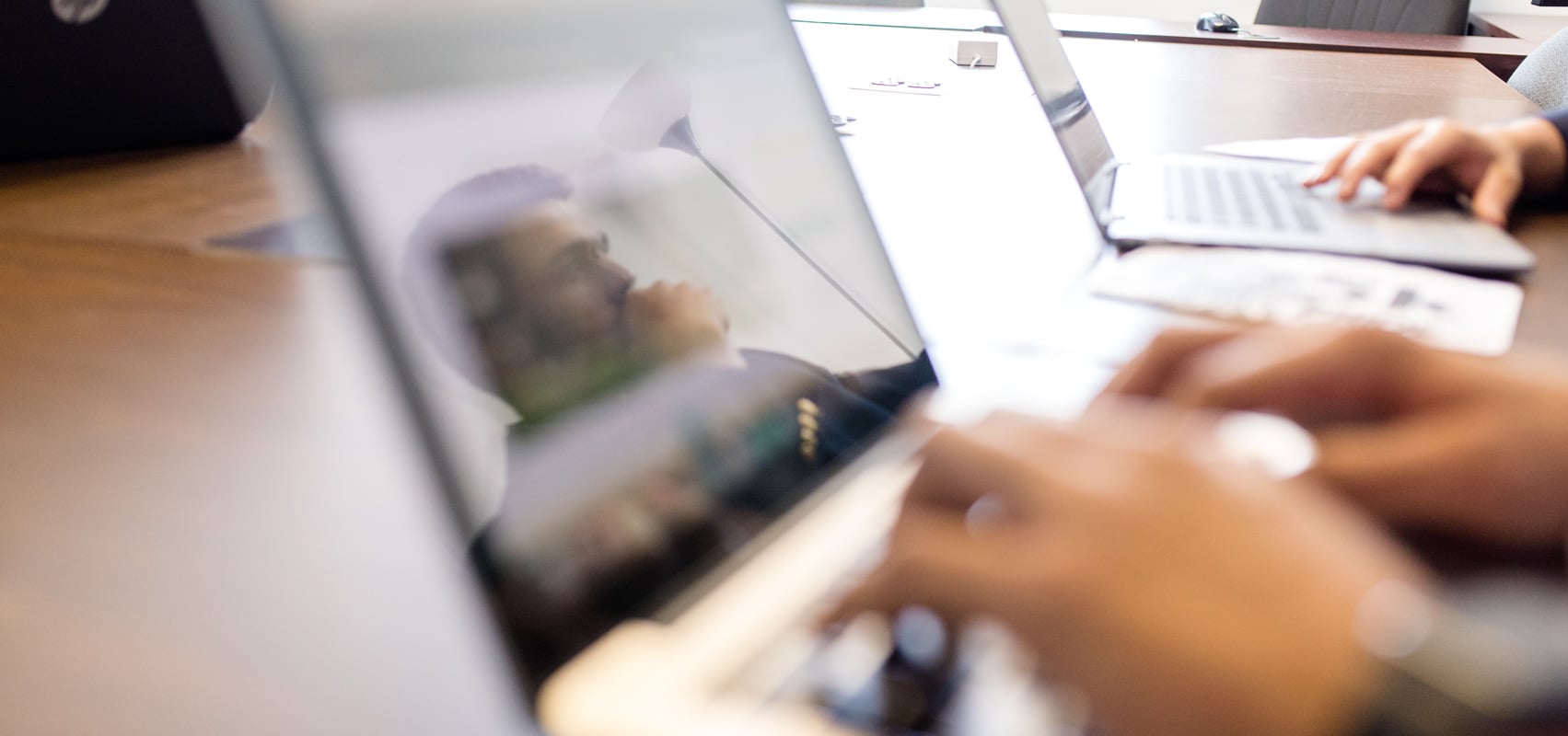 Blurred view of hands working on laptop computers