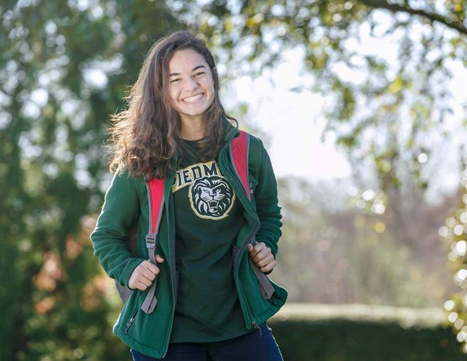 Young woman with a backpack posing and smiling