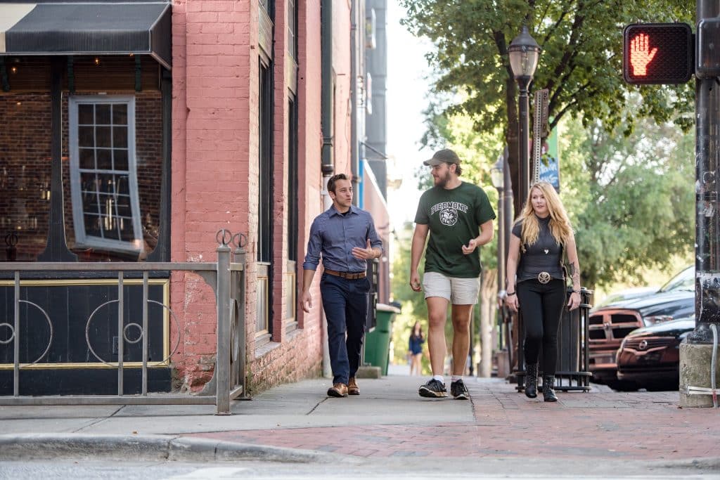 Three students walking to a crosswalk on the Athens campus