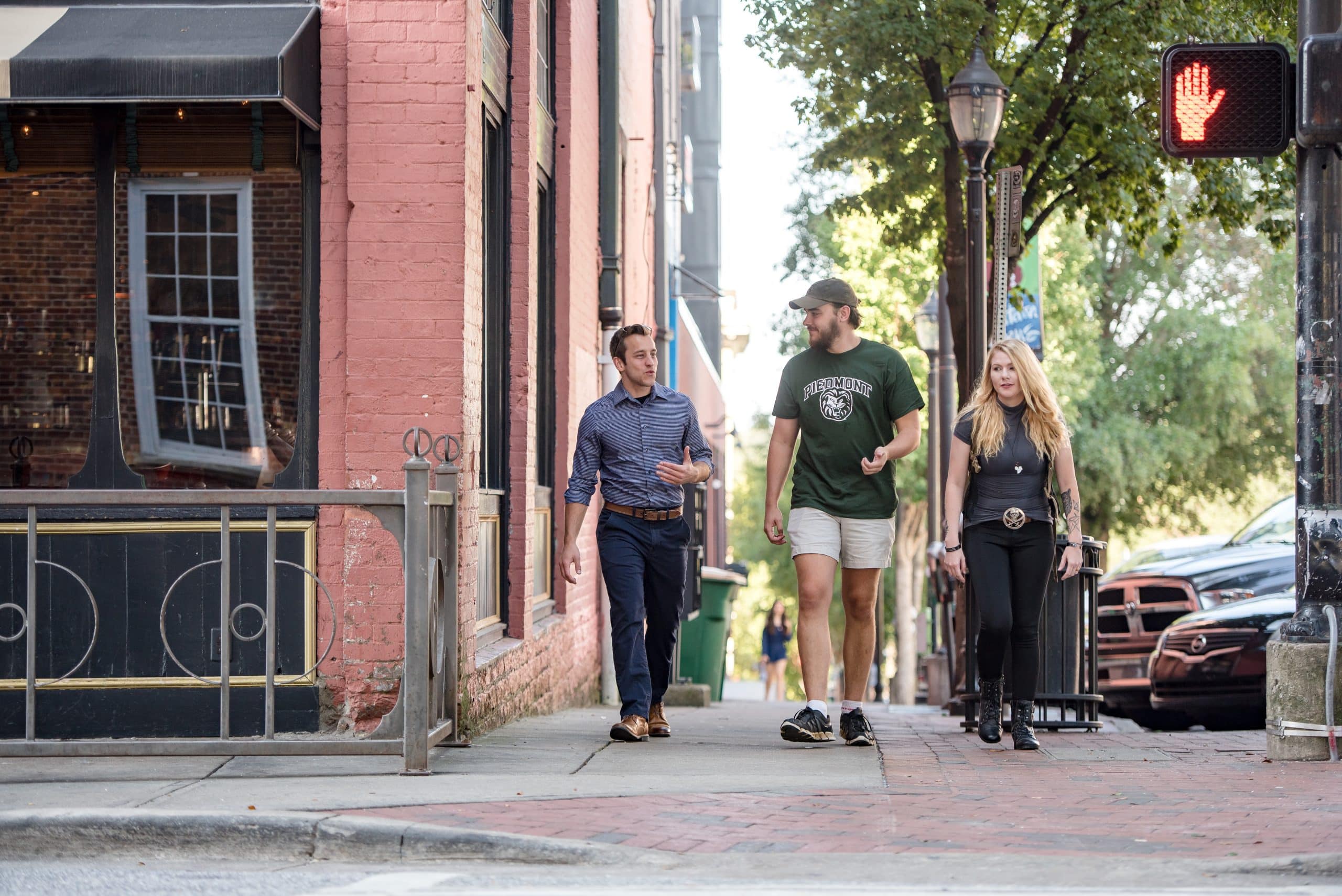 Three students walking to a crosswalk on the Athens campus