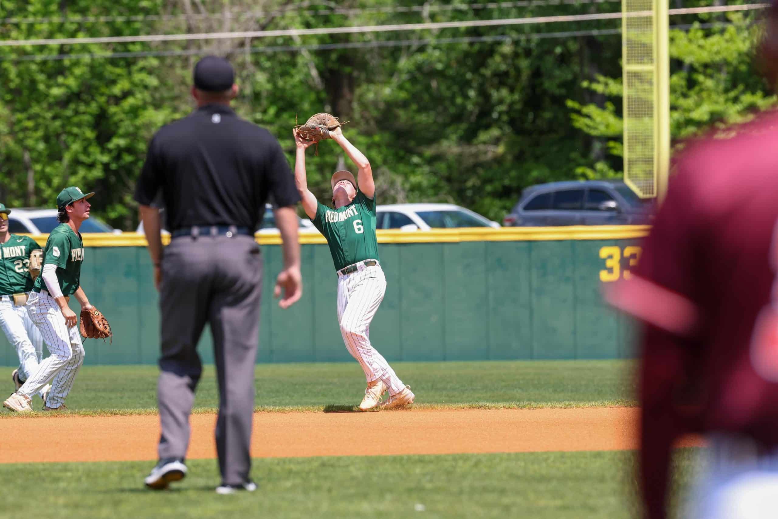 Baseball player standing on a base catching a ball