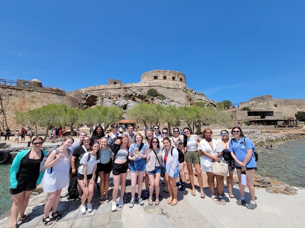 Students posing in front of the ruins of a castle