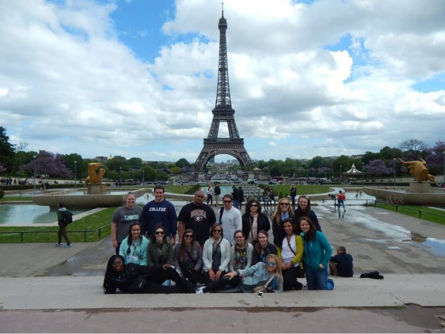 Students posing at the base of the Eiffel Tower in Paris