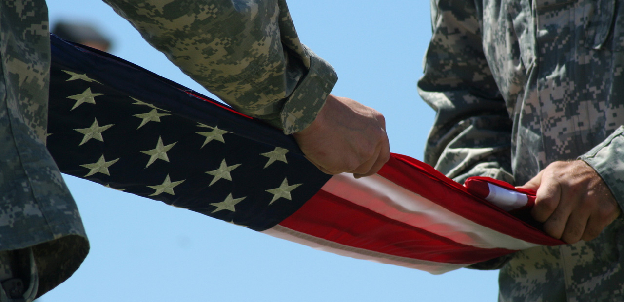 Two US military officers are seen folding the United States flag