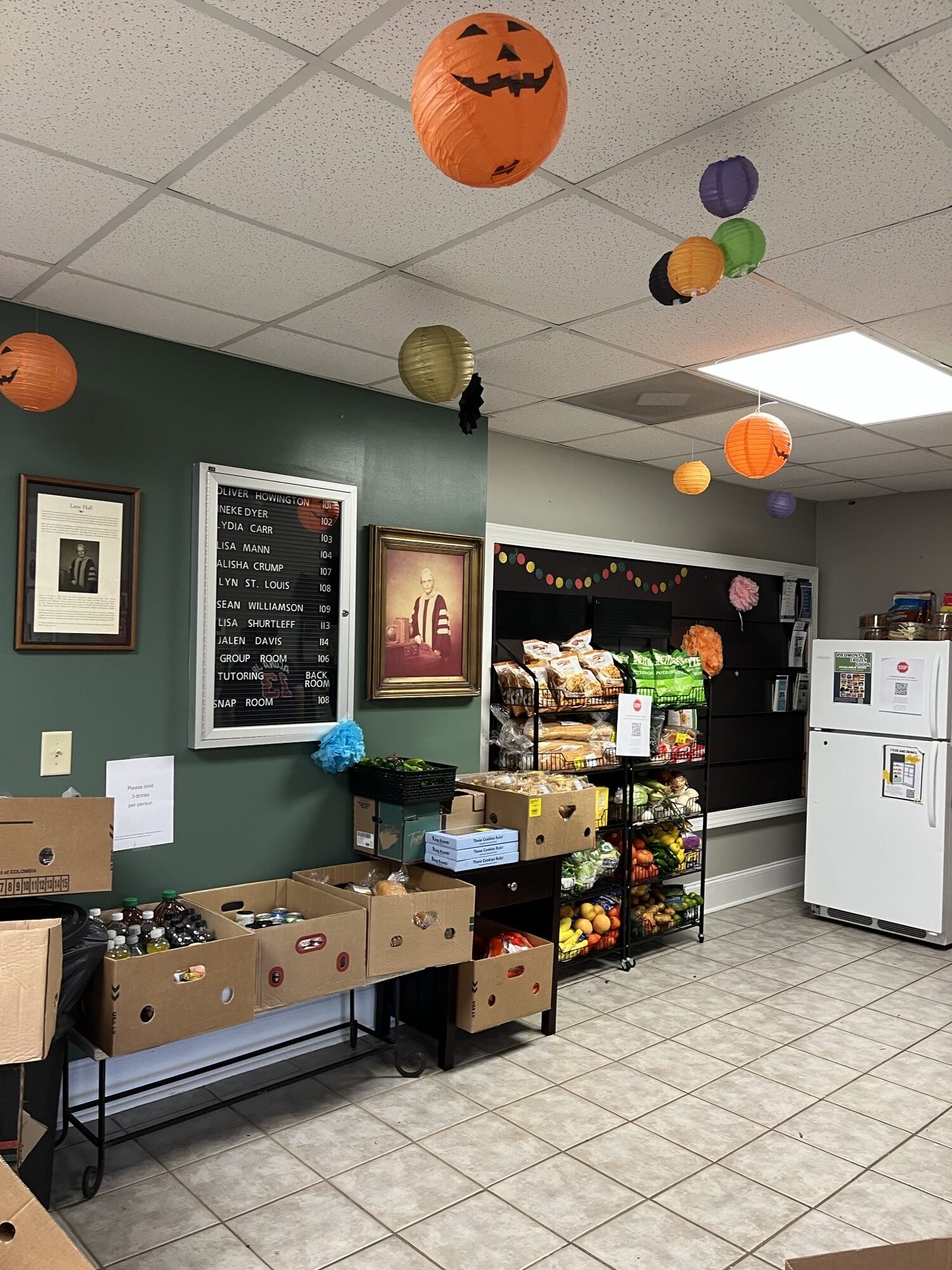 A lobby containing shelves filled with food and a refrigerator.